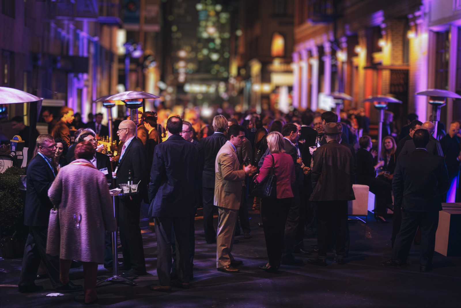 Group of people socializing at an event in an alley
